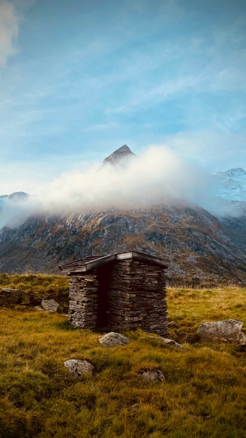 a small hut with a mountain in the background