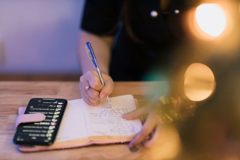 a woman is doing a writing task on her notebook