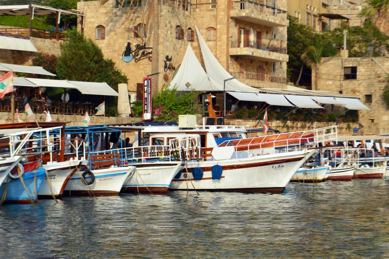 many colorful boats are docked near some buildings