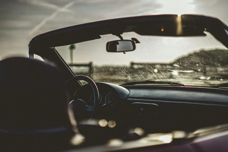 the inside view of an automobile window that shows a city street