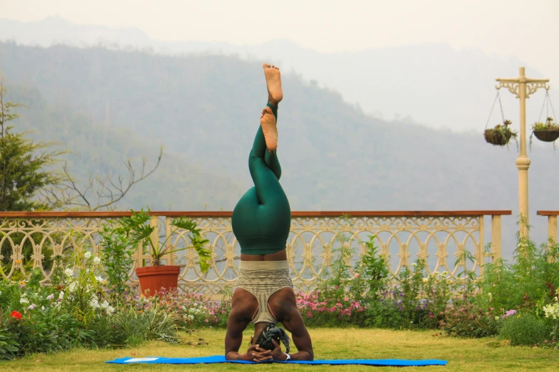 the person is practicing yoga in a lawn