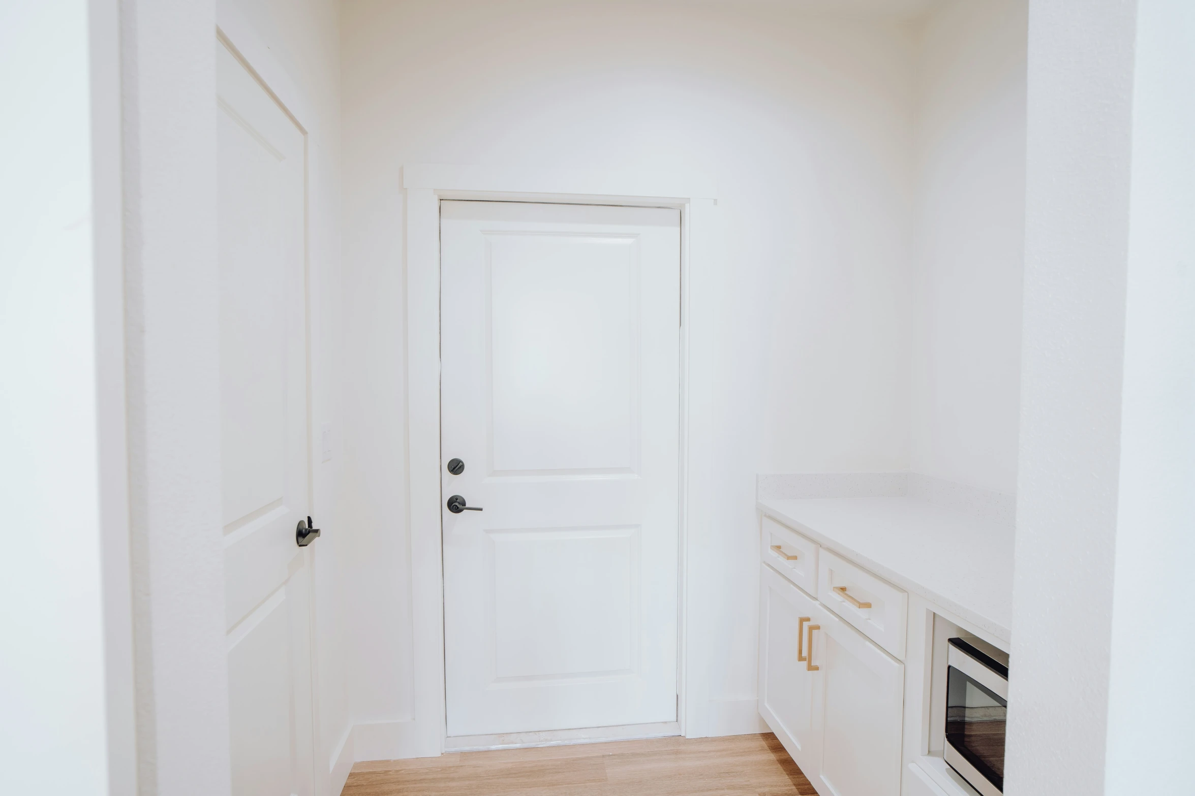 a very clean kitchen with white appliances and hardwood floor