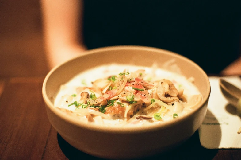 a bowl of soup sits on the table next to some other food