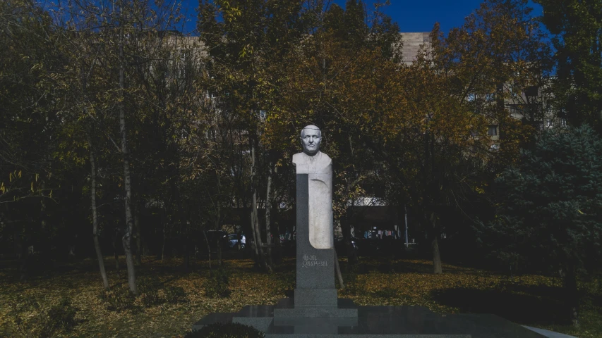 a park with a statue and several trees in the background