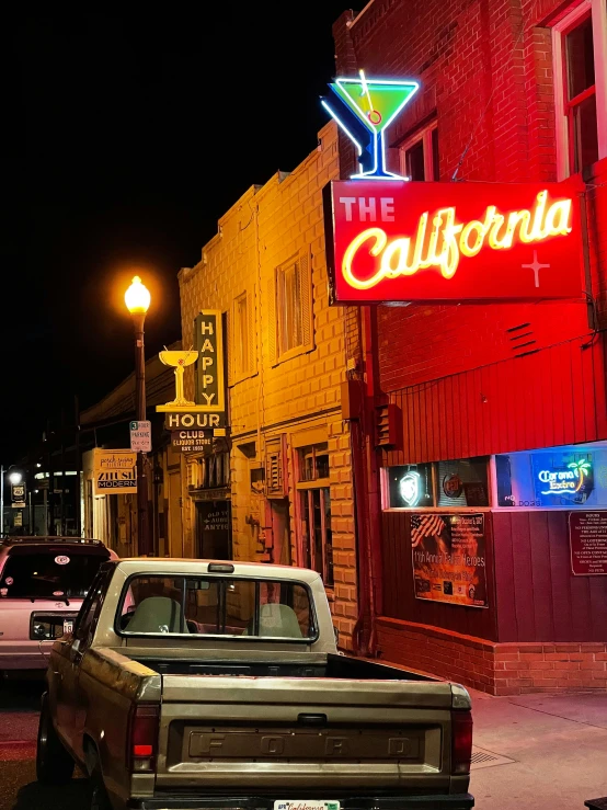 car on the side of the road with billboard lights and signs