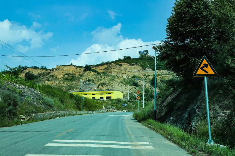 an open street with yellow house on it