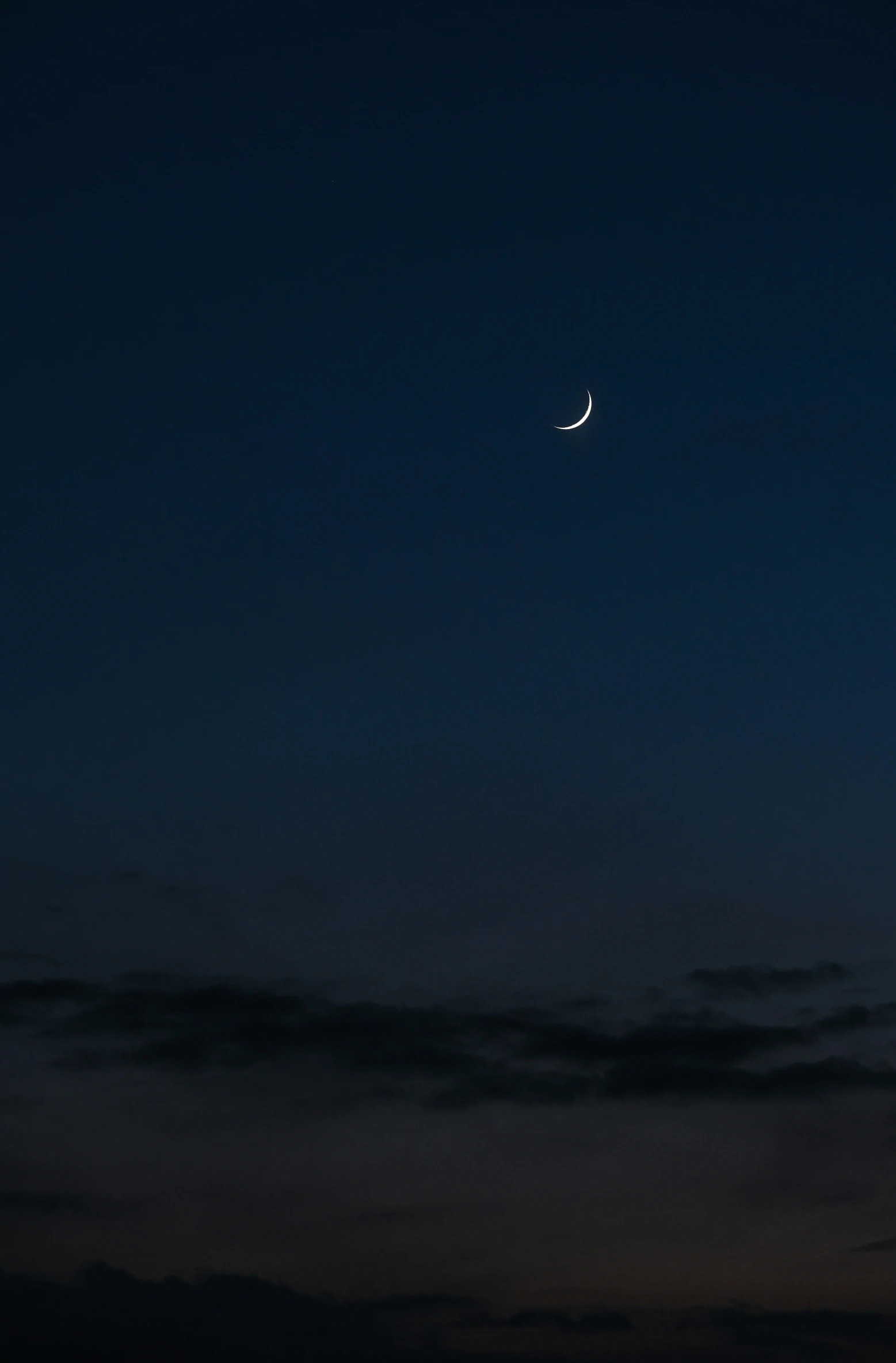 the moon is visible at night with a dark sky