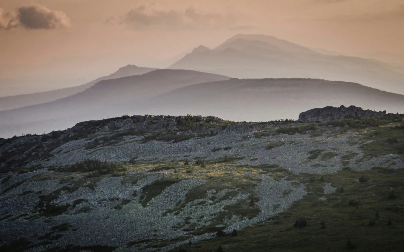 the mountains are covered in fog as they sit high on a cloudy day