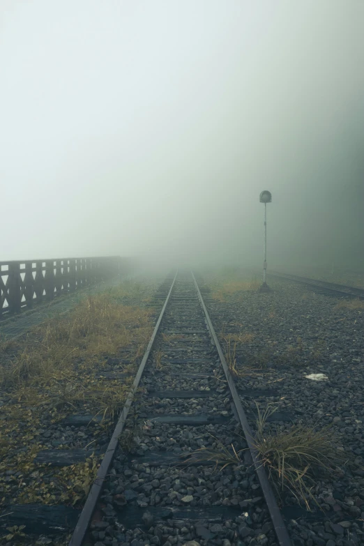 train tracks and railroad in fog on a train track