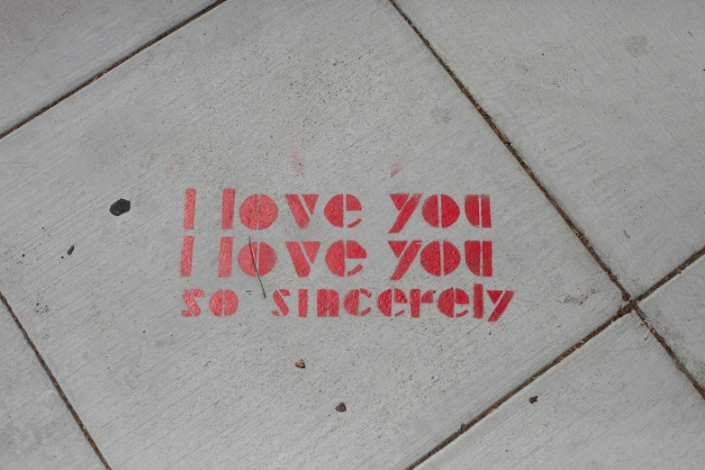 the word i love you are written on the sidewalk