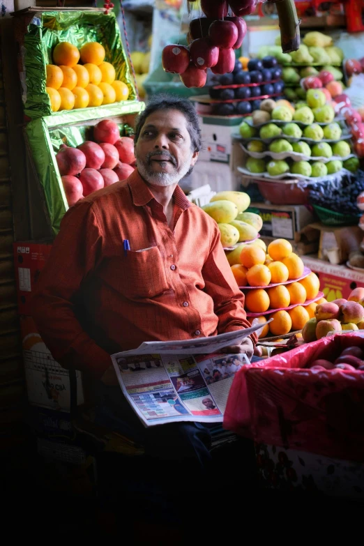 the man is looking at some fruit in his stand