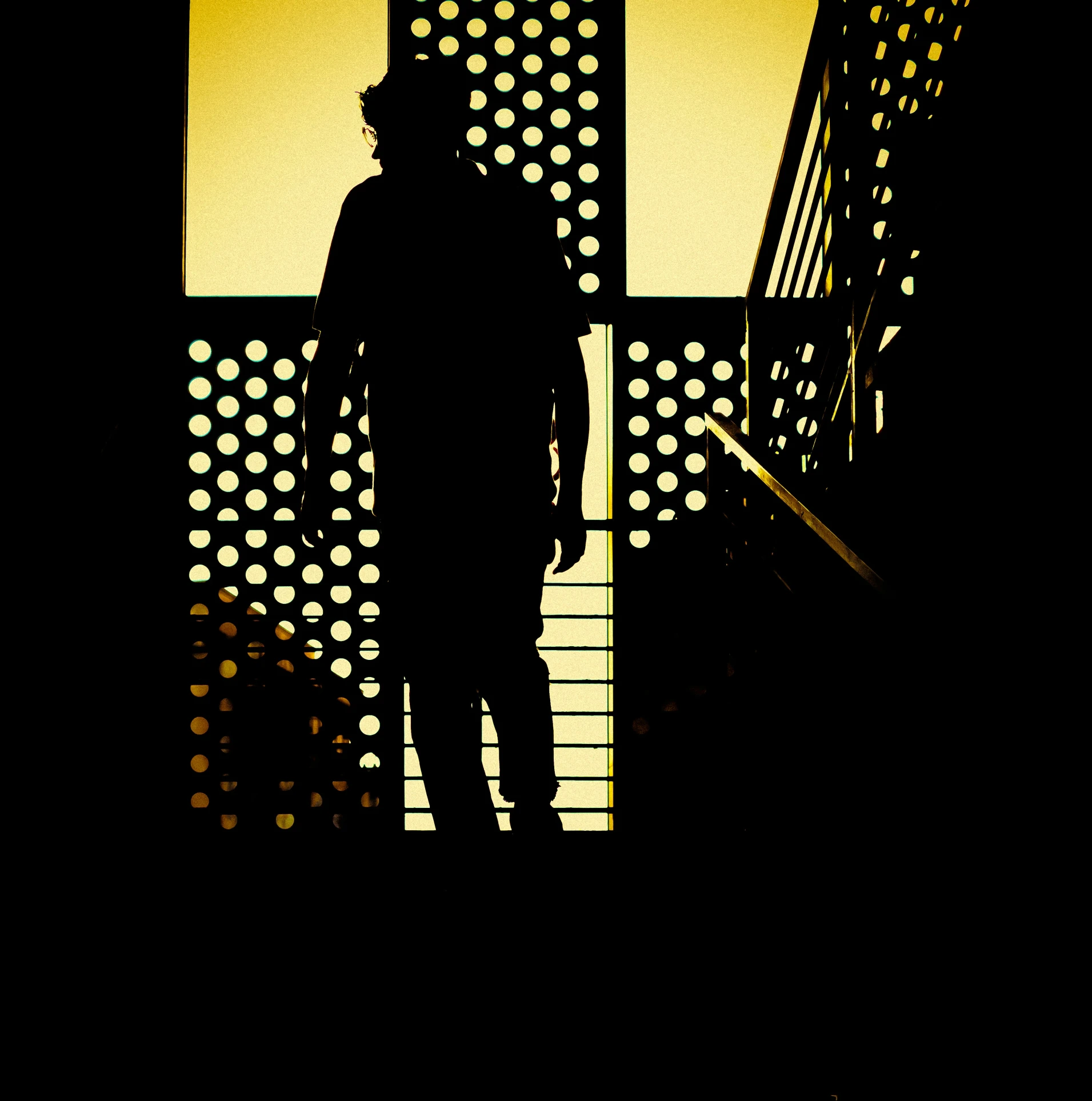 a silhouette of a man standing on the top of a bridge