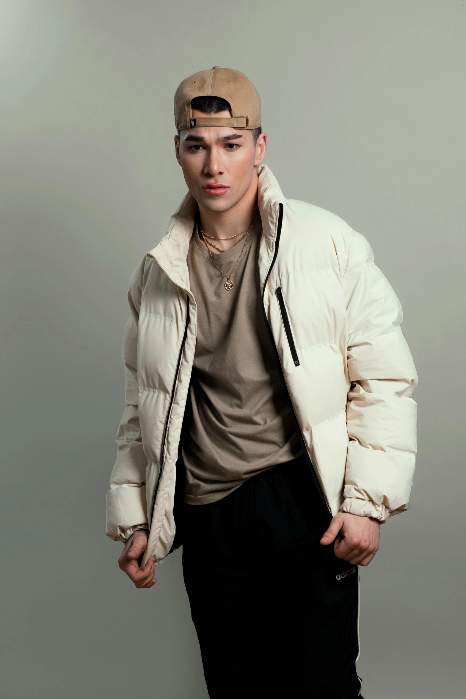 young man in white down jacket and black pants