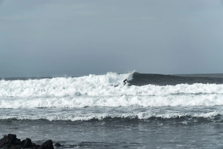 a man riding a wave on top of a surfboard