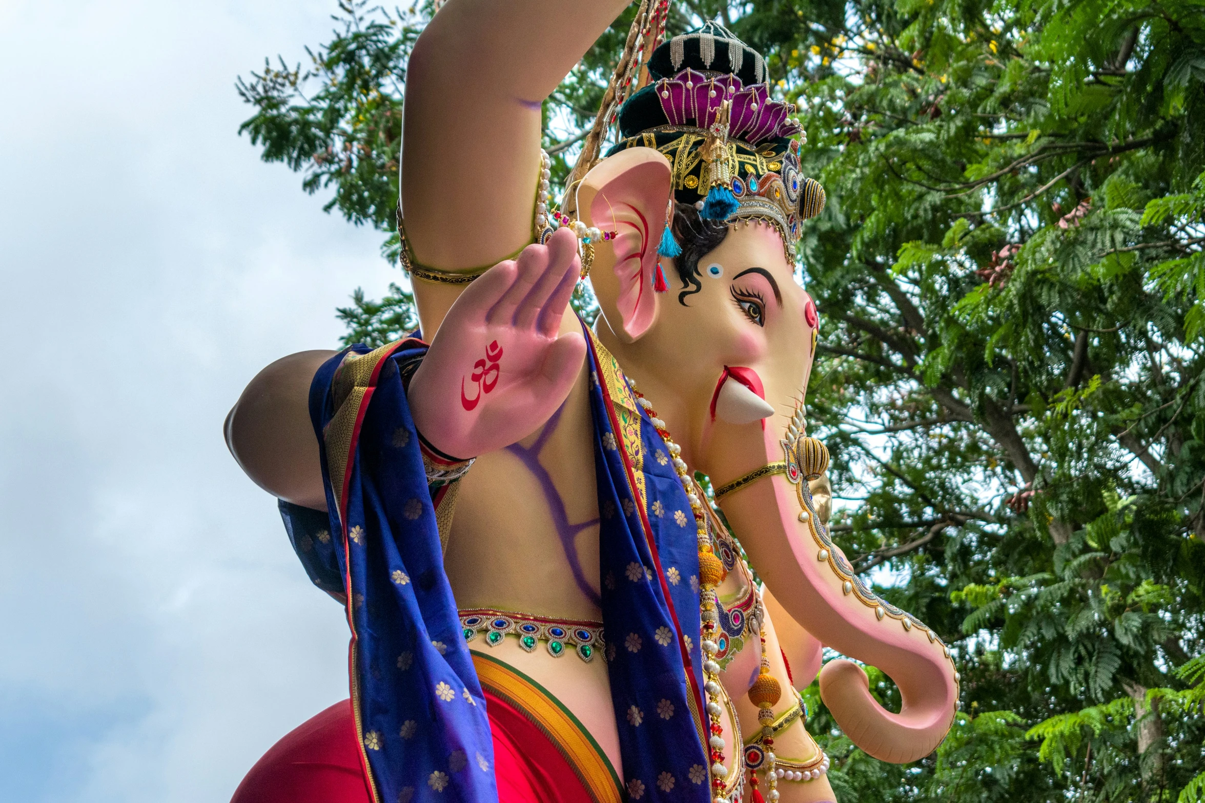 an ornate elephant with colorful costume on top of a tree