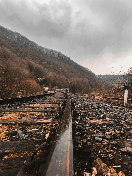 a man stands on the tracks with a view of the mountains