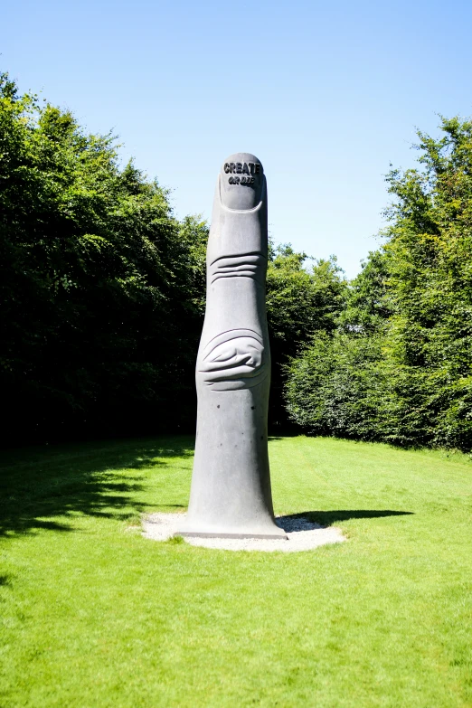 a statue of a foot that is standing in the middle of some grass