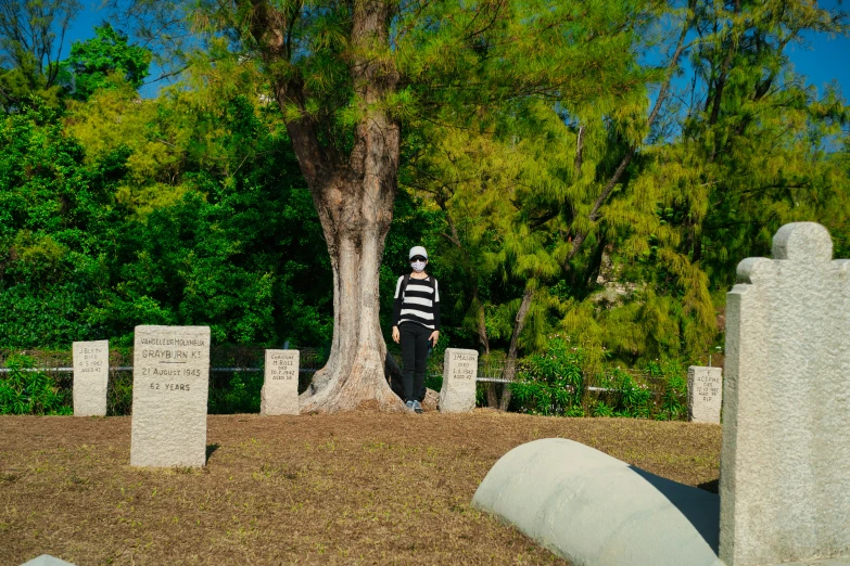 person wearing black and white standing next to a tree