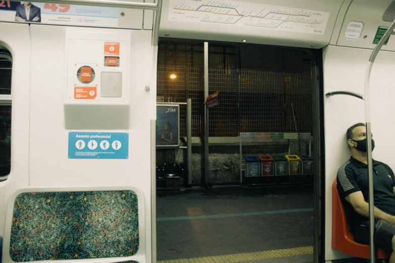 two people sitting inside a subway car as the lights come on