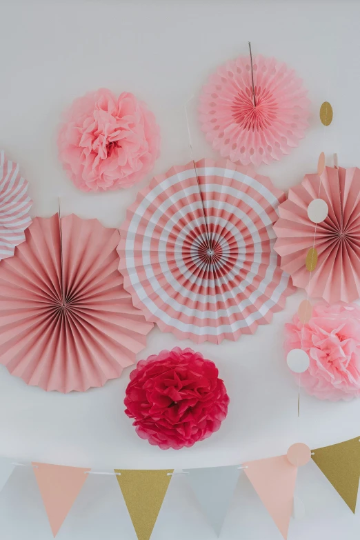 many decorative paper flowers and some pink paper fans