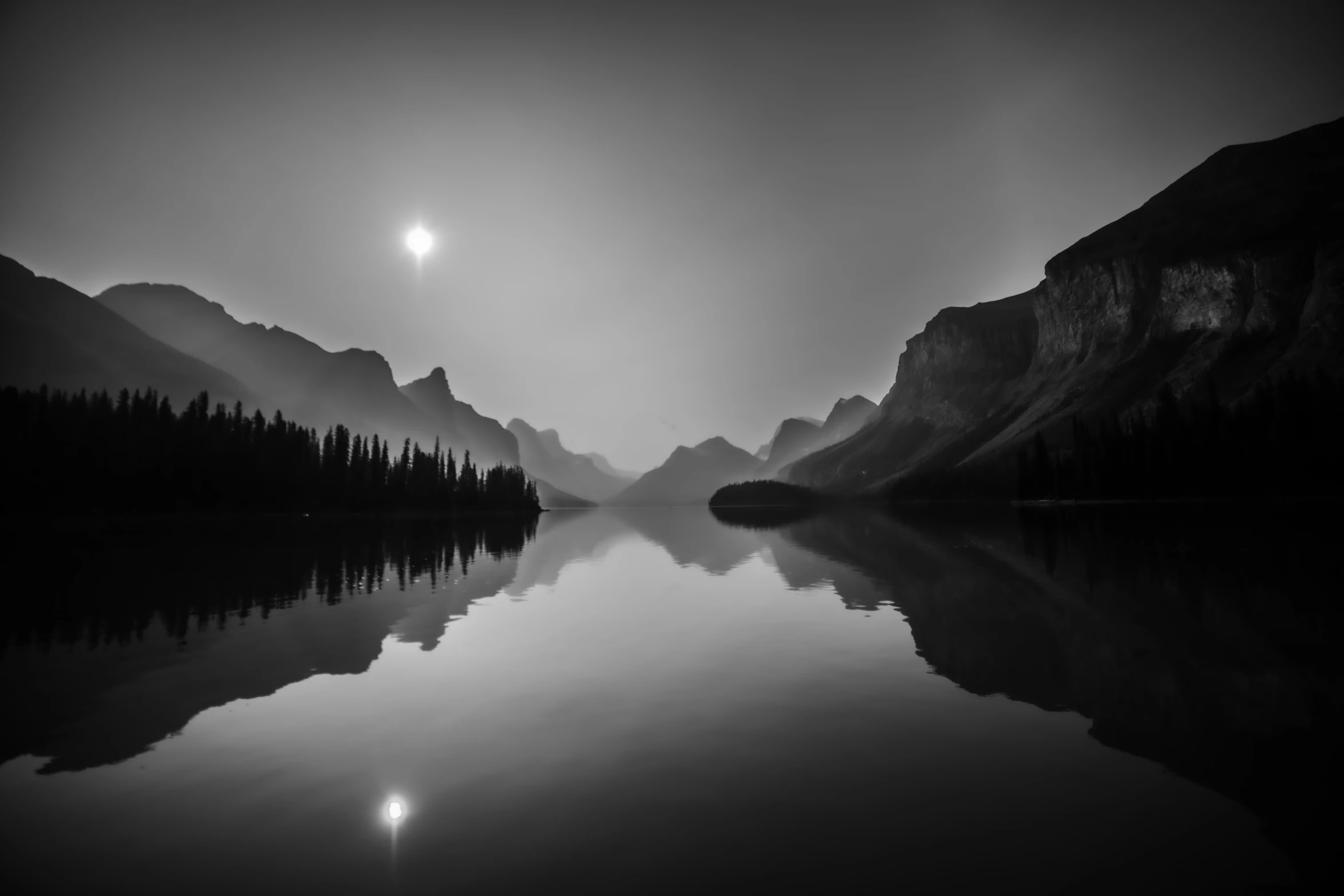 the dark lake is surrounded by many mountains