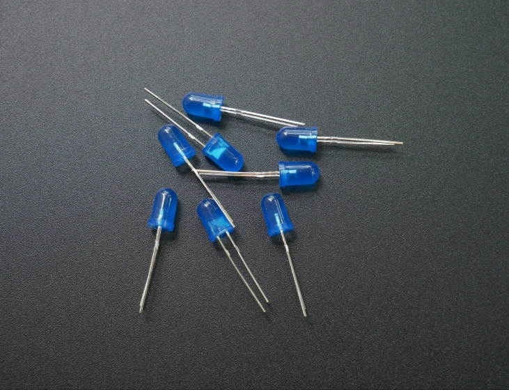 several blue toothpicks are stacked on top of each other