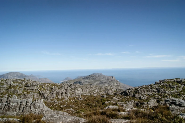 rocks and weeds surround the ground on the top of a mountain