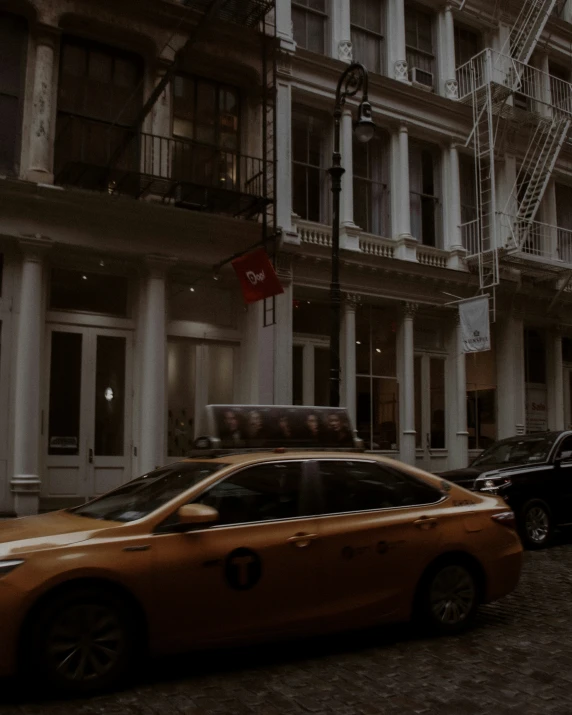 a taxi cab drives down a street in the middle of an old town