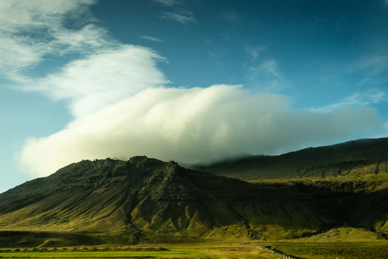 a mountain covered with a cloud and trees