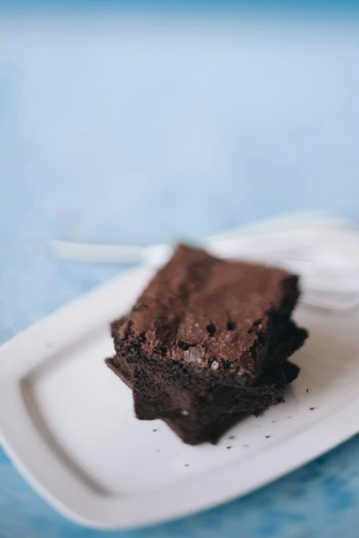 the plate has a fork in it and a piece of chocolate cake