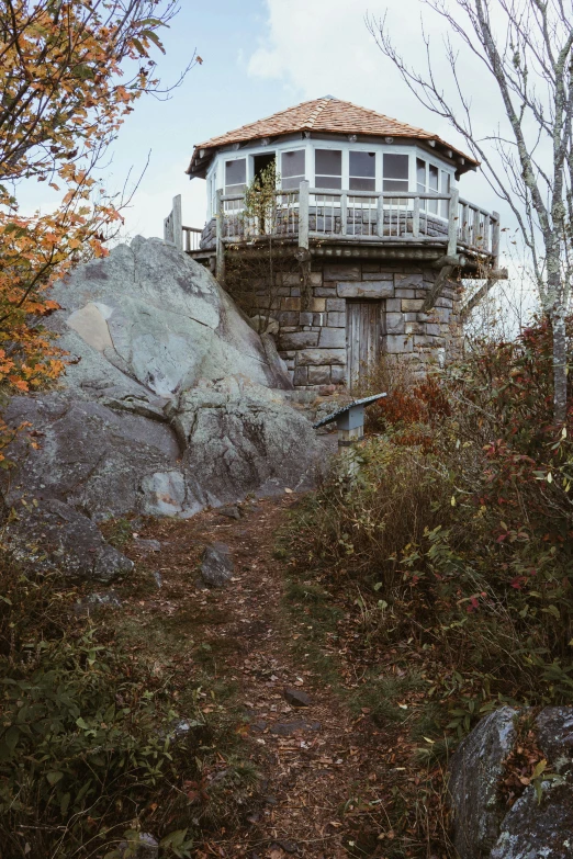 a house on top of a cliff and a hill in front