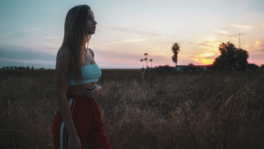 a woman standing in a field looking into the distance