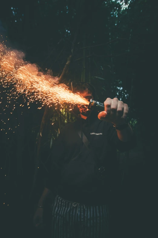 a man using a handheld tool to light up some fireworks