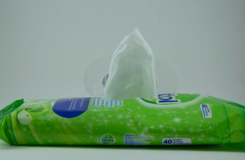 a green bag of wipes sitting on top of a white table