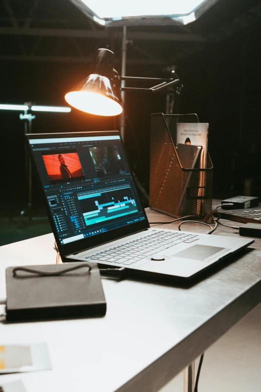 a laptop on a desk with a lamp on it