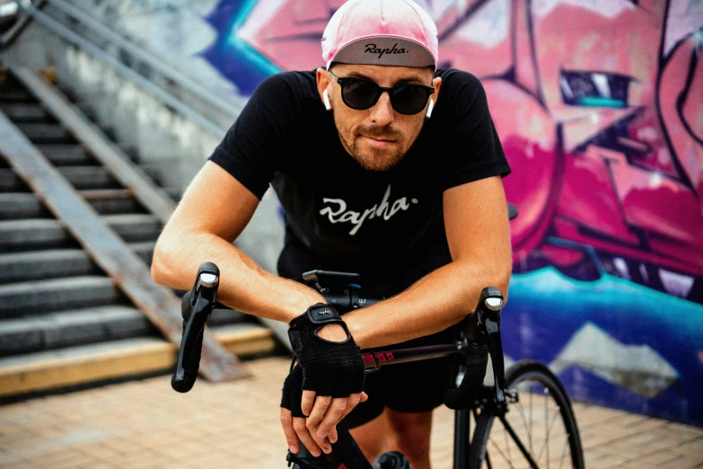 a man riding his bike by some graffiti