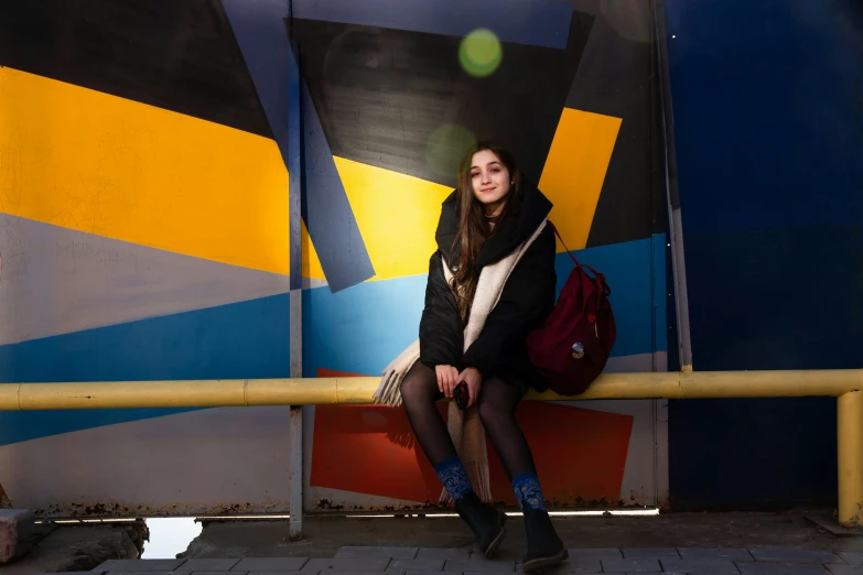 a girl sitting on a colorful bench in front of a building