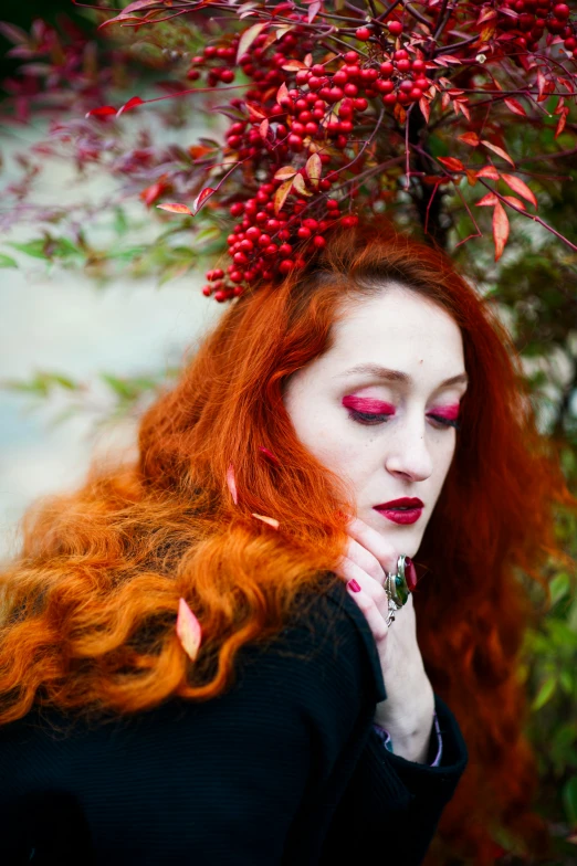 a woman with red hair and bright makeup poses for the camera