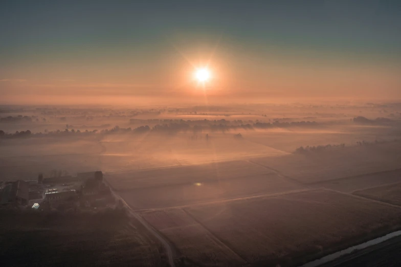 sun rays shine down over a hazy countryside