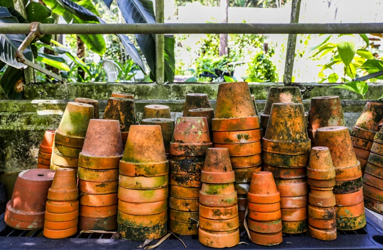 a bunch of old pots that are on a rack