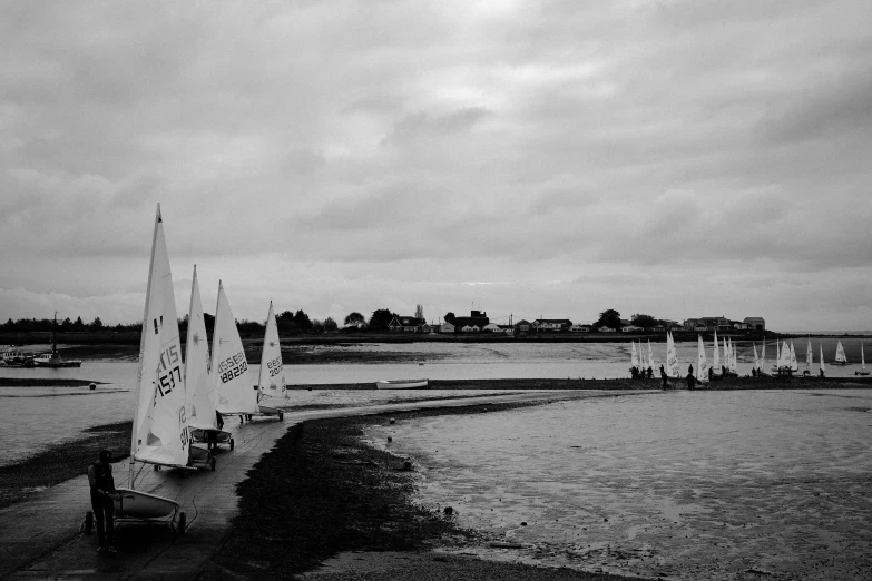 a sail boat parked on the beach next to the water