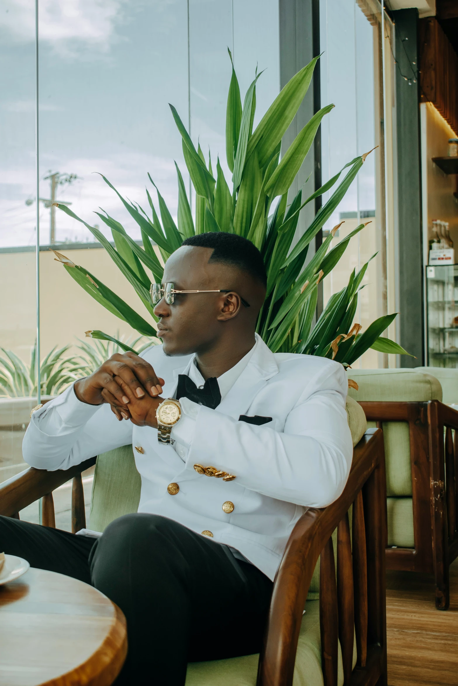 a man in a sailor's outfit with a watch and a plant