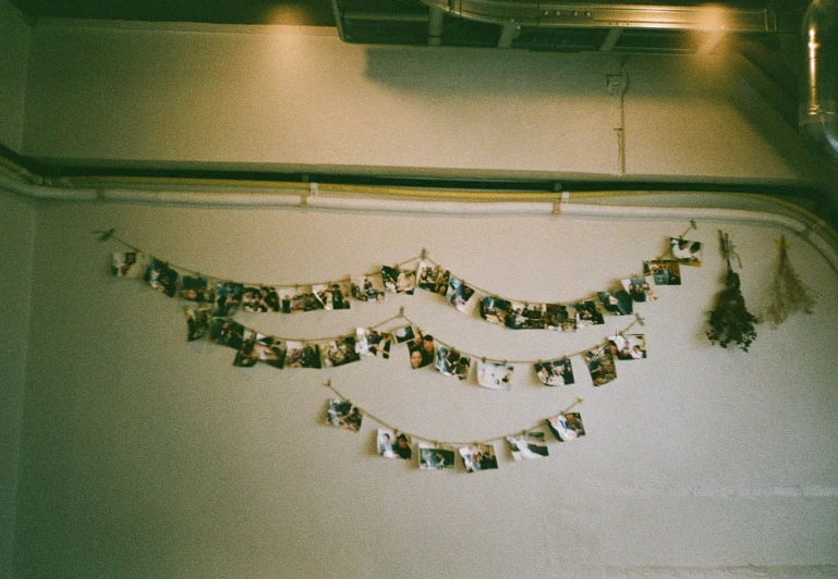 several pictures hanging on a wire on the wall