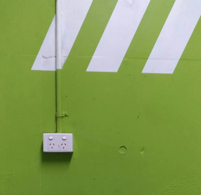 this is an electrical meter attached to a green wall
