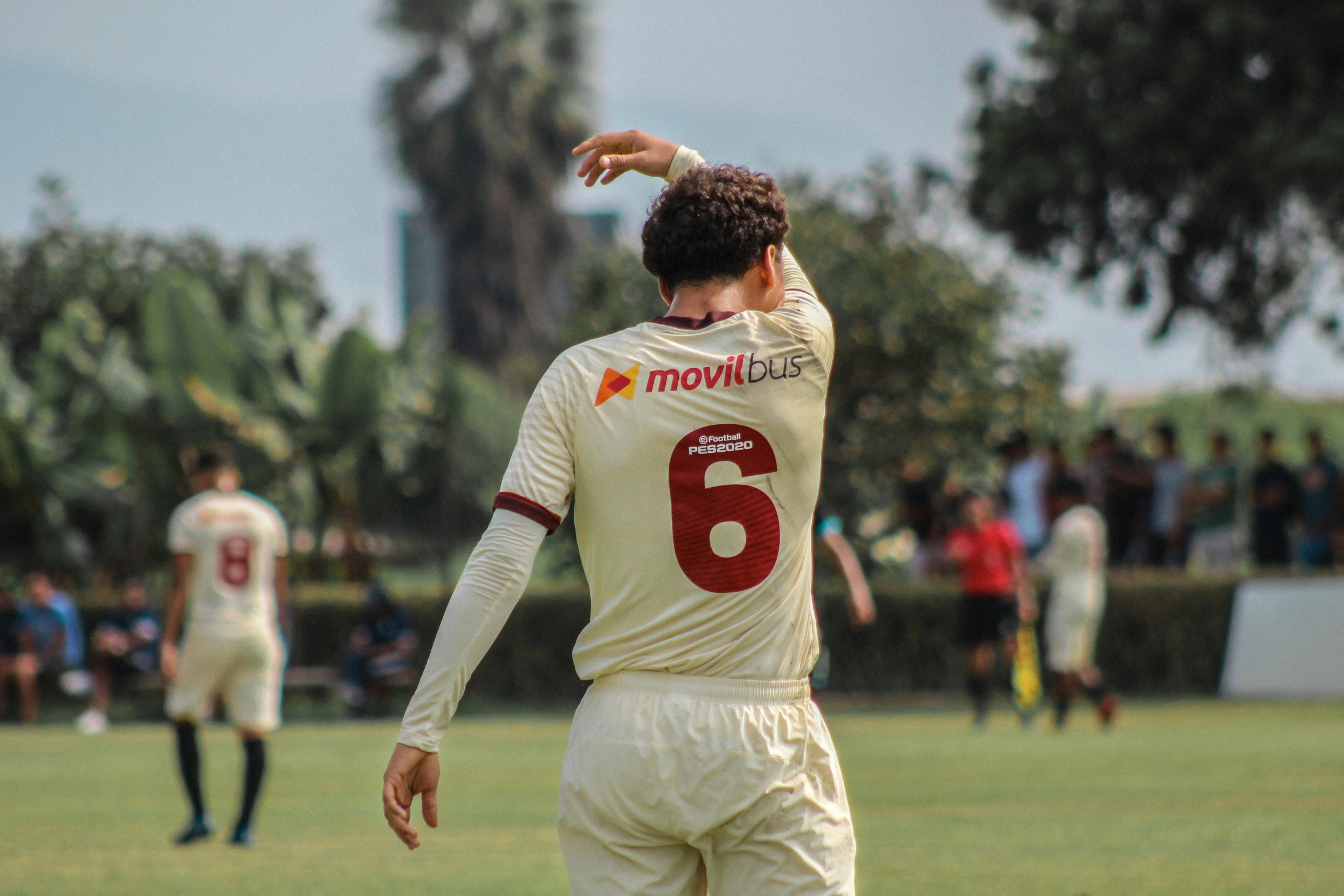 a man in white jersey throwing a ball on field