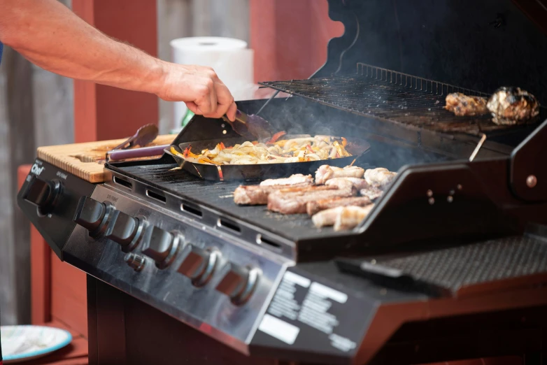 a man grilling food outside on a grill