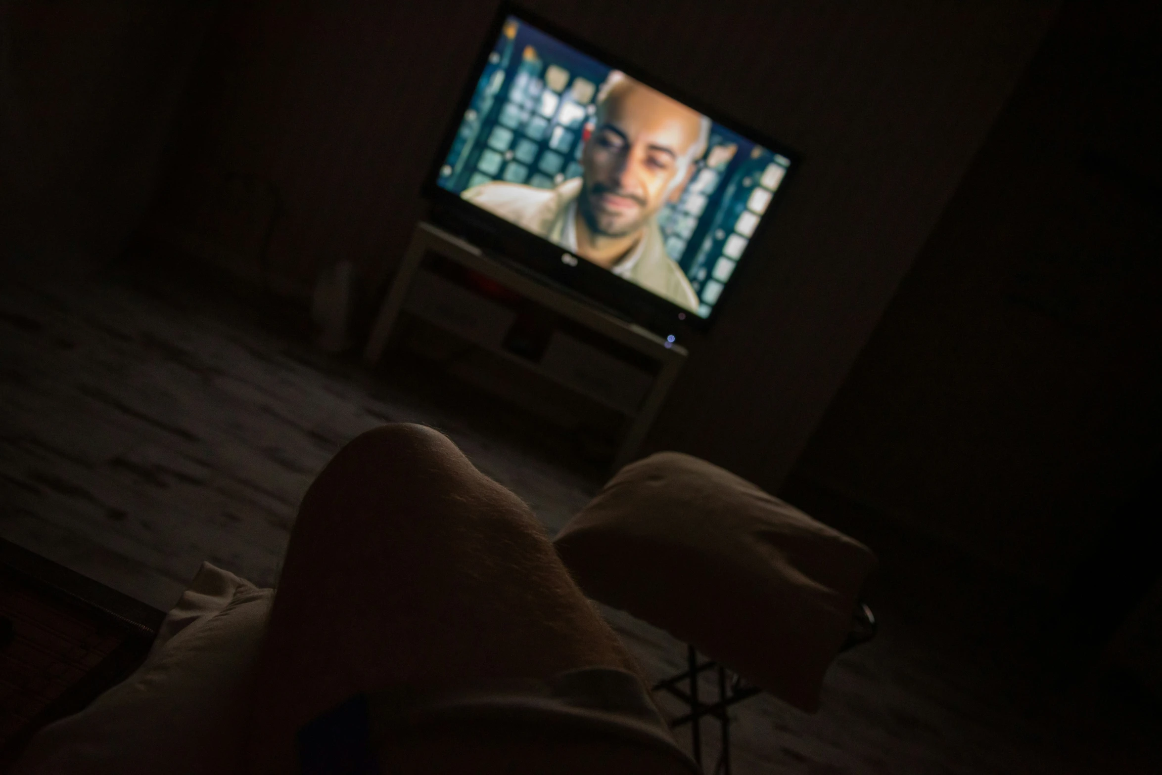 a person's feet are on the floor in front of a television screen