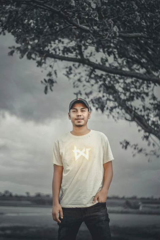 a man standing under a tree wearing a hat