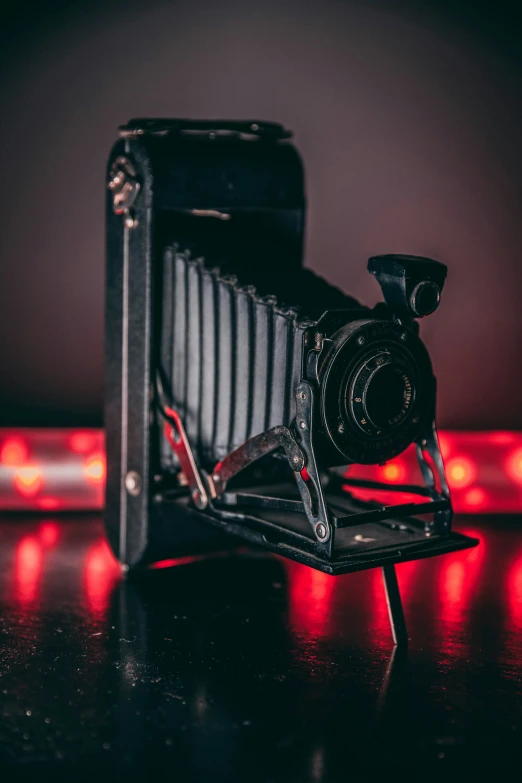 an old fashioned camera on a stand next to a red light