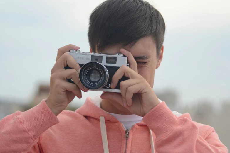 a  holding a camera and taking a picture